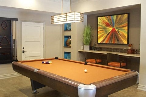 a pool table in a living room with a painting