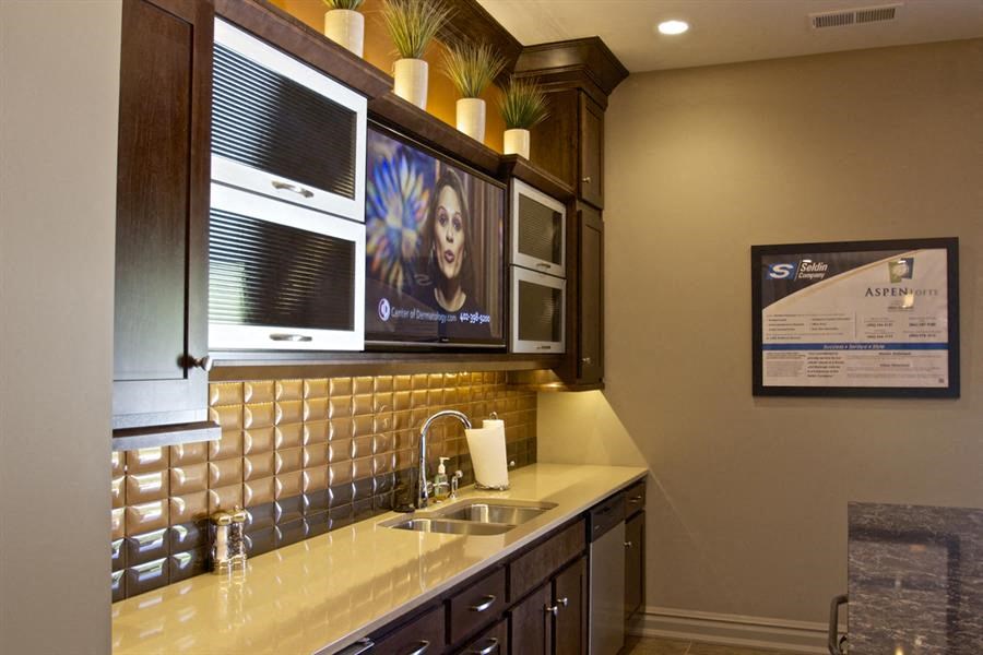 a kitchen with a sink and two microwaves on the wall