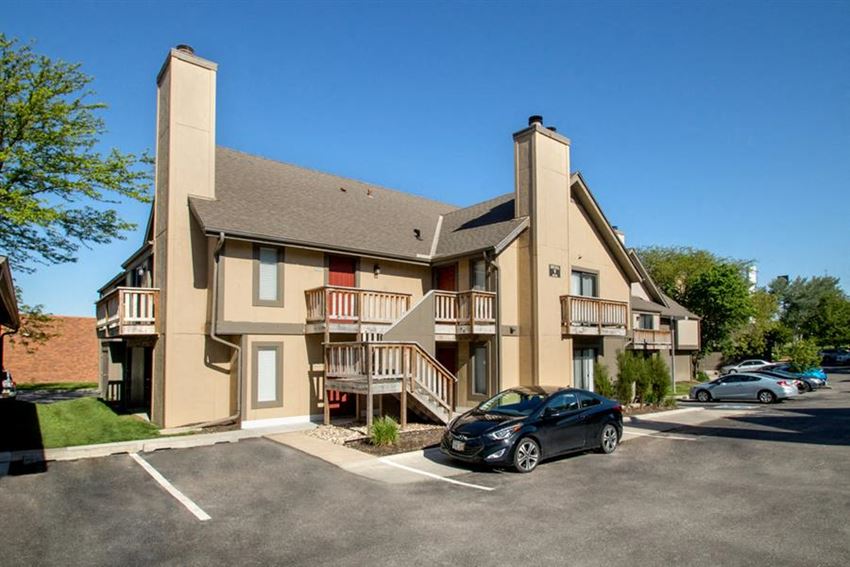 an apartment building with a car parked in a parking lot