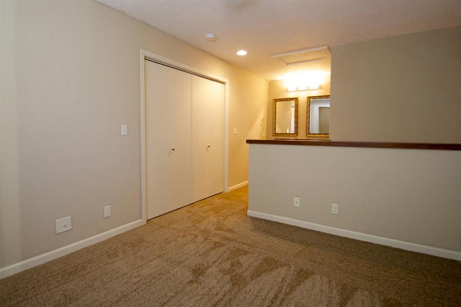 a empty living room with a mirror and a door