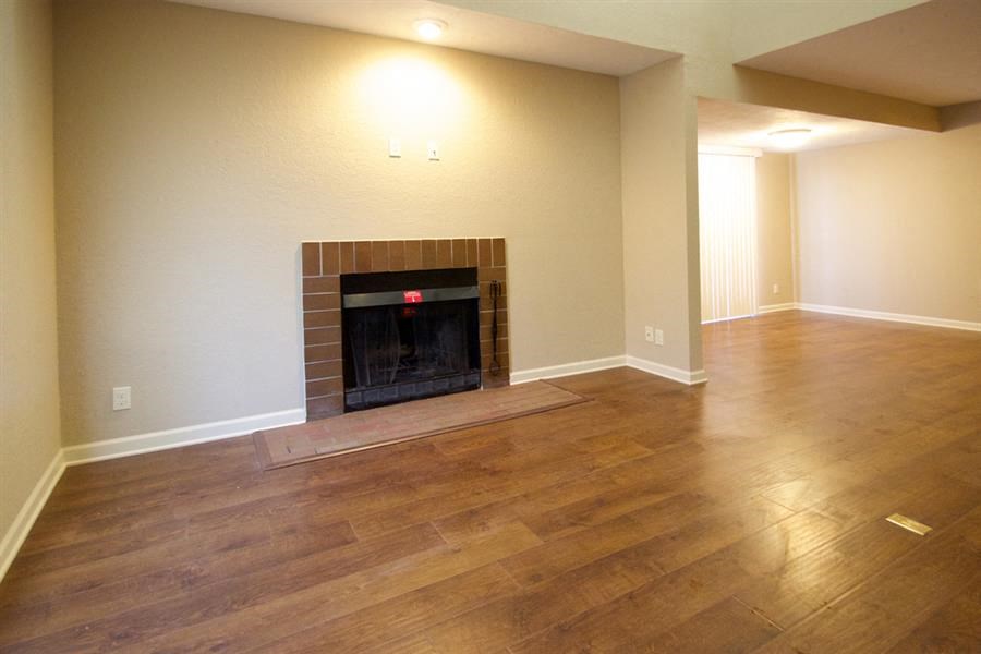 a living room with a fireplace and a wooden floor