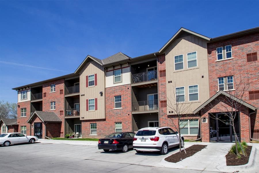 an apartment building with cars parked in front