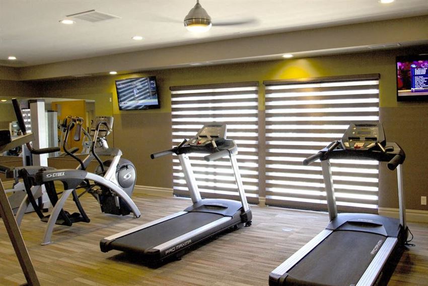 a gym with various machines and weights in it