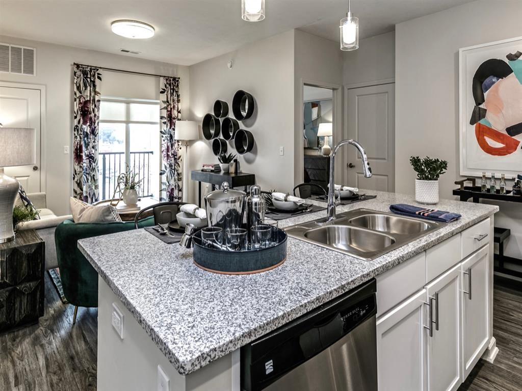 an open kitchen and living room with a granite counter top