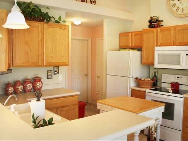 a kitchen with white appliances and wooden cabinets