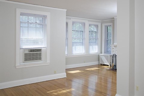 an empty living room with a wood floor and windows