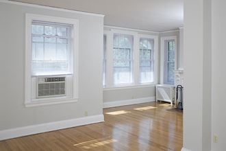 an empty living room with a wood floor and windows