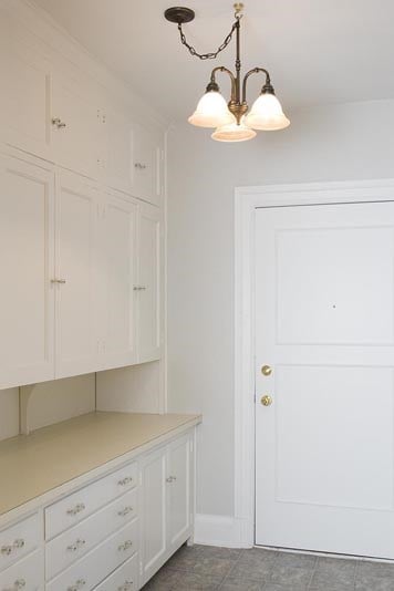 a white kitchen with white cabinets and a light