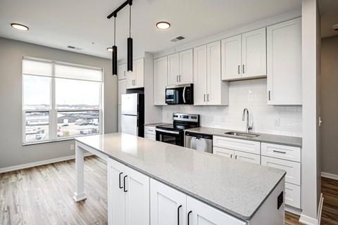 A kitchen with white cabinets and a large island.
