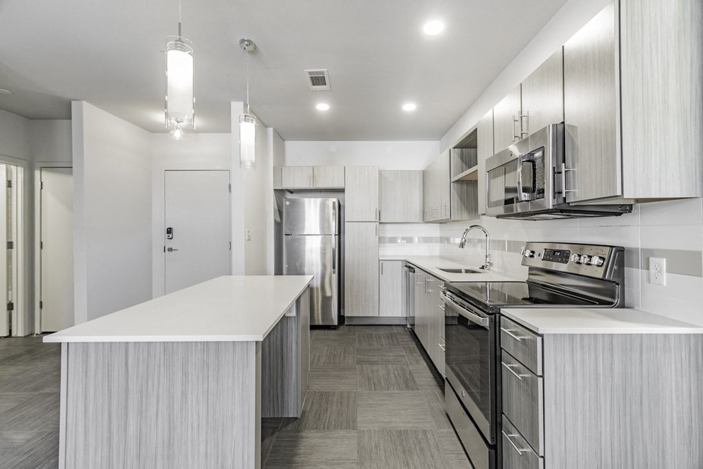 One and two Bedroom Apartment Homes with Large Kitchens with ample storage and light cabinets, quarts countertops and stainless steel appliances at Pinnacle Heights Apartments in Rogers, Arkansas