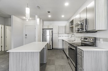 One and two Bedroom Apartment Homes with Large Kitchens with ample storage and light cabinets, quarts countertops and stainless steel appliances at Pinnacle Heights Apartments in Rogers, Arkansas - Photo Gallery 3