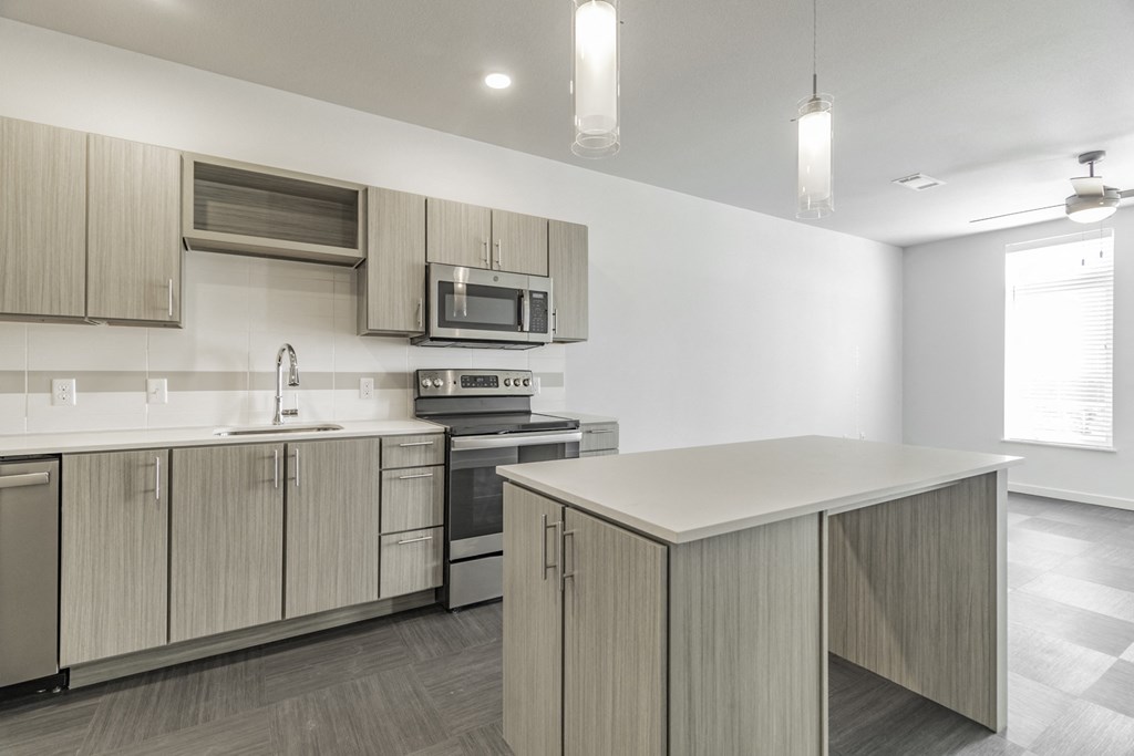 One and two Bedroom Apartment Homes with Large Kitchens with ample storage and light cabinets, quarts countertops and stainless steel appliances at Pinnacle Heights Apartments in Rogers, Arkansas