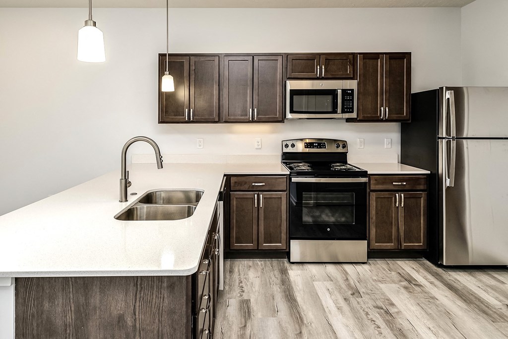 Kitchen with dark wood cabinets and white countertops at Belle Point in Bellevue, NE