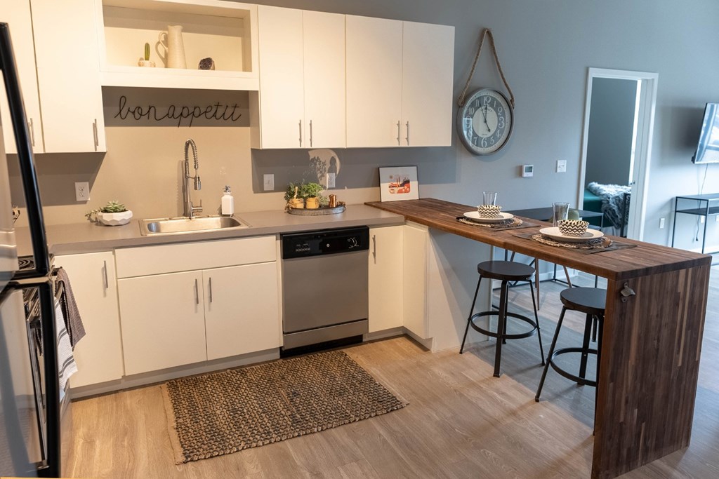 Studio, one, and two-bedroom apartment featuring stainless steel appliances, artistic industrial design, custom butcher block island, in-unit washer and dryer, and more at Benson Lights Apartments in Benson, NE