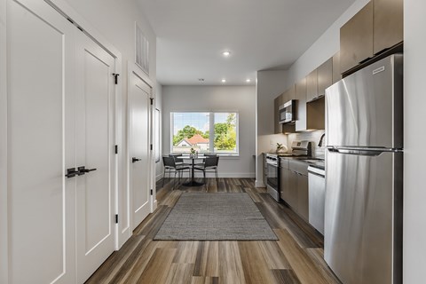 A modern kitchen with a dining table and chairs in the background.