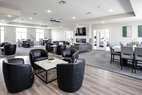 a large living room with chairs and tables and a tv