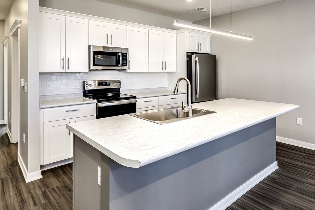 a kitchen with white cabinets and a large counter top