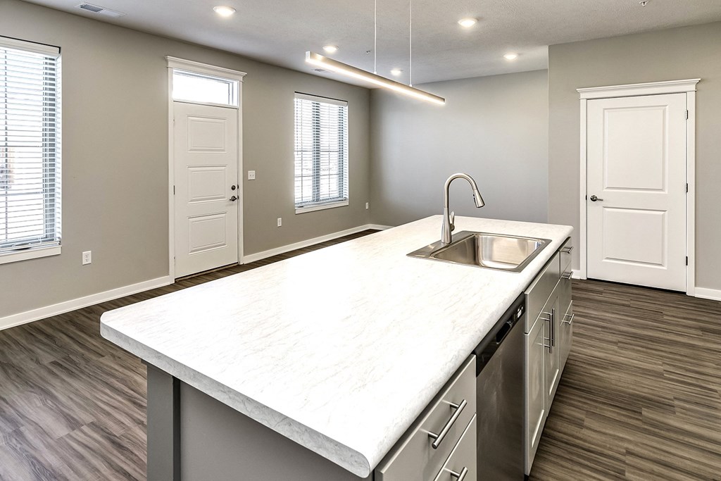 an empty kitchen with a large counter top and a sink