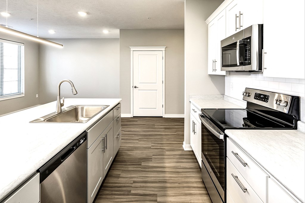 a renovated kitchen with white cabinets and stainless steel appliances
