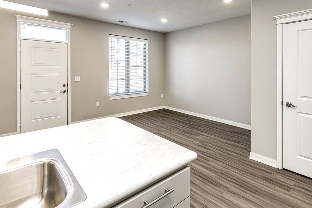 an empty kitchen and living room with a sink and a window