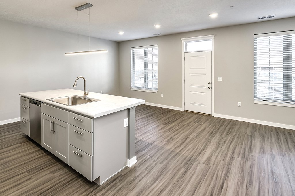 an empty kitchen and living room with a sink and window