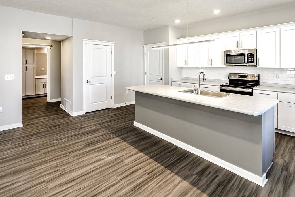a kitchen with white cabinets and a counter top and a sink