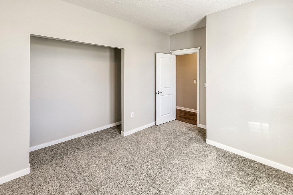 an empty room with white walls and a carpeted floor