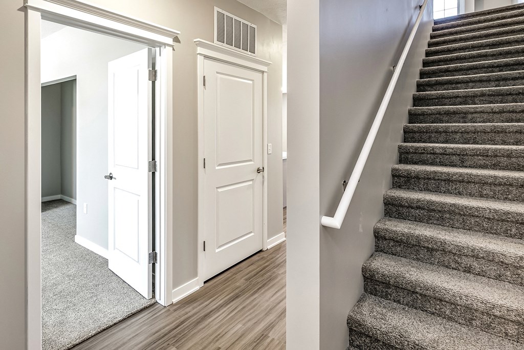 a view of a staircase in a home with stairs and a door to a hallway