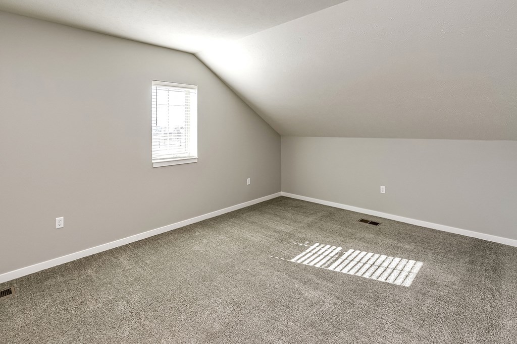 an empty room with carpet and a window