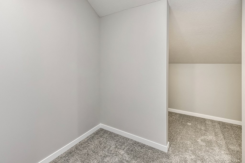 an empty room with gray carpet and white walls