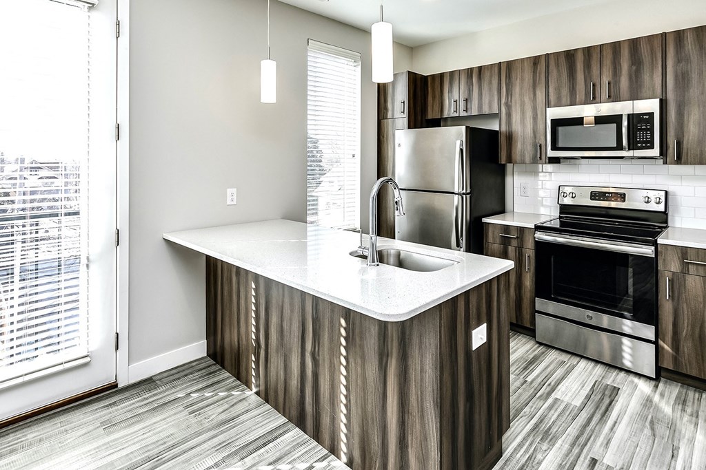 a kitchen with a large island and stainless steel appliances