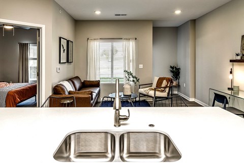 a kitchen with a sink and a view of a living room