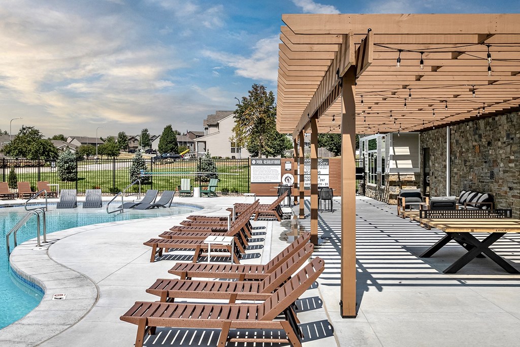 Relaxing pool area with lounge chairs at Hanover Flats in Bennington, NE