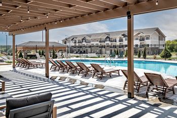 Resort-style pool with lounge chairs at Hanover Flats in Bennington, NE