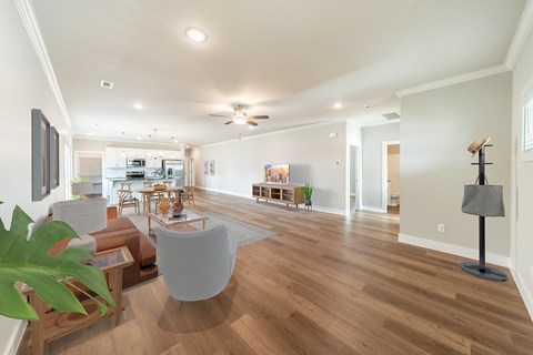 A living room with a white couch and a wooden floor.