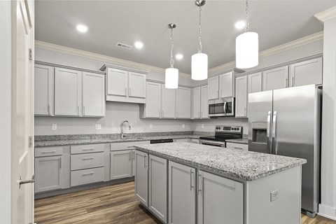 a large kitchen with white cabinets and granite counter tops