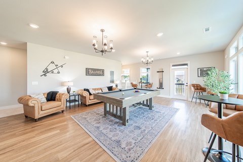 a living room with a pool table in the center of it