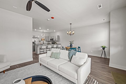 a living room with a white couch and a ceiling fan