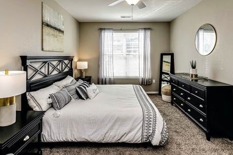 Luxurious bedroom with a large window  at Legacy Commons Apartments in Omaha, NE