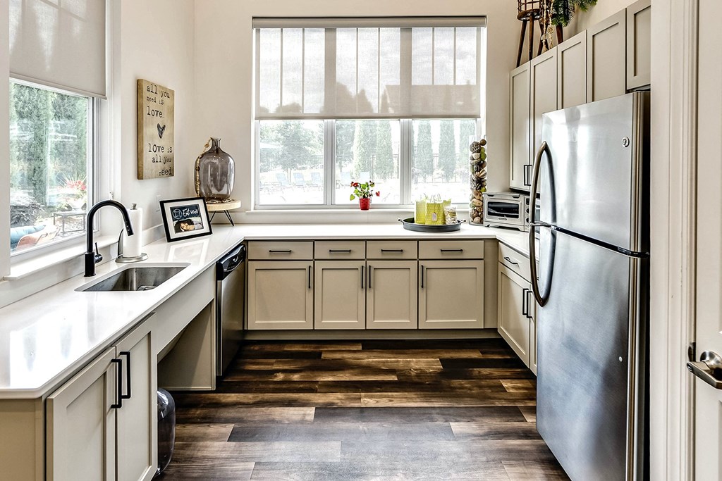 Clubhouse Kitchen with white cabinets and a stainless steel refrigerator at Legacy Commons Apartments in Omaha, NE