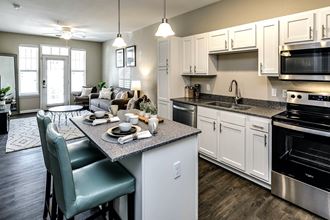 an open floor plan with a kitchen and living room at Legacy Commons Apartments in Omaha, NE
