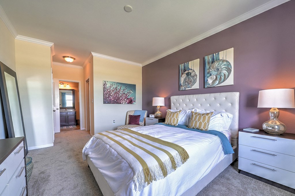 a bedroom with purple walls and a white bed