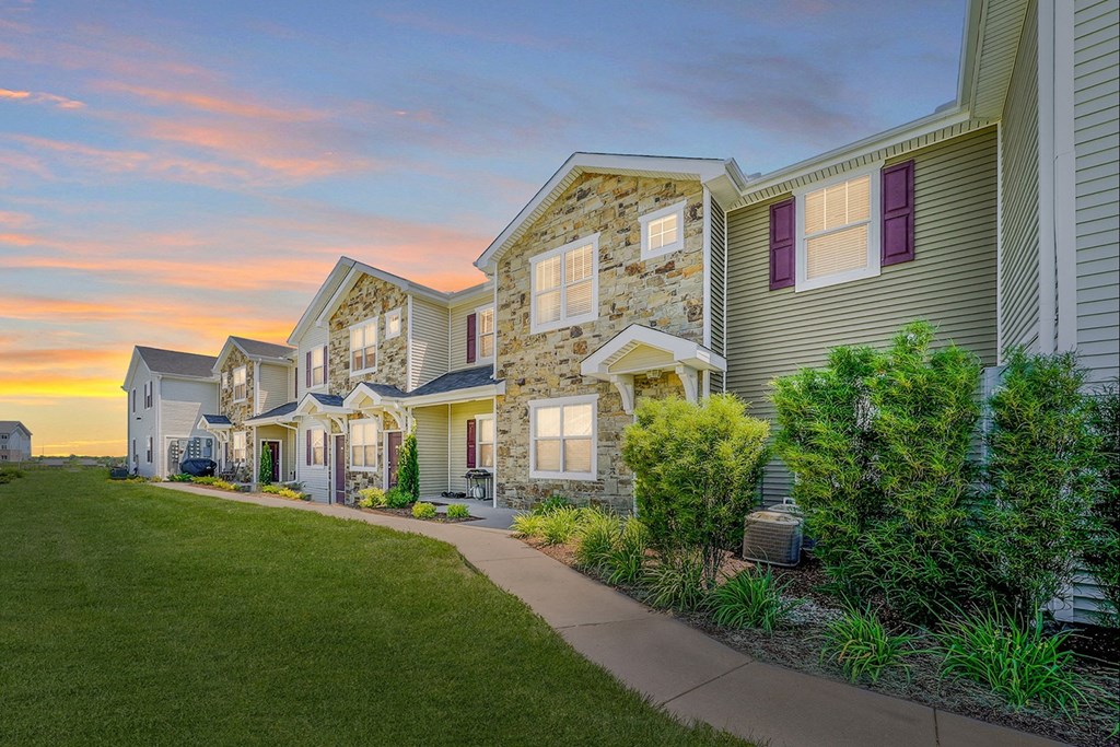 a row of townhomes with a sunset in the background