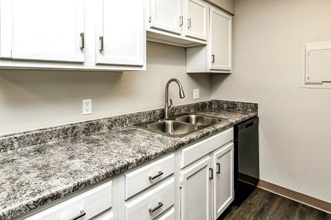 a kitchen with white cabinets and granite counter tops and a sink