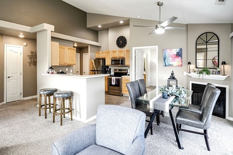 A modern living room with a grey couch and a glass table.