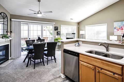 A kitchen with a dining table and chairs.
