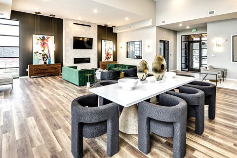 A modern dining room with a white table and grey chairs.