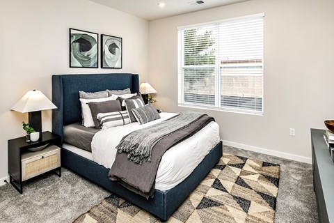 A bedroom with a large bed and two lamps.