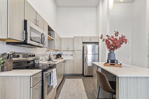 a kitchen with white cabinets and stainless steel appliances and a white counter top