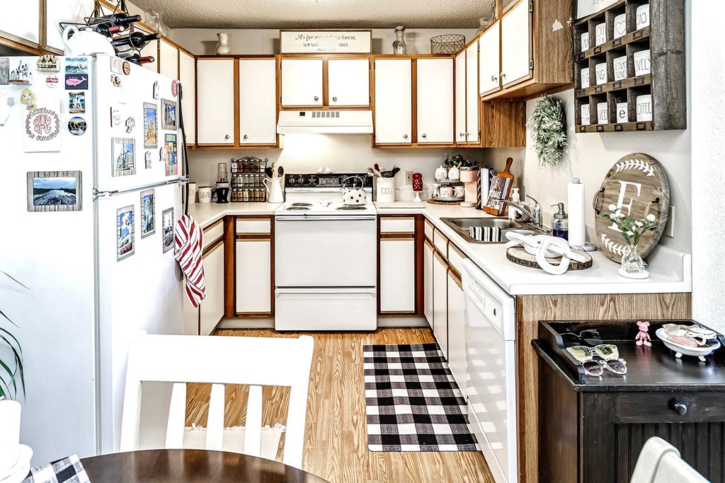 a kitchen with white appliances and a black and white checkered floor